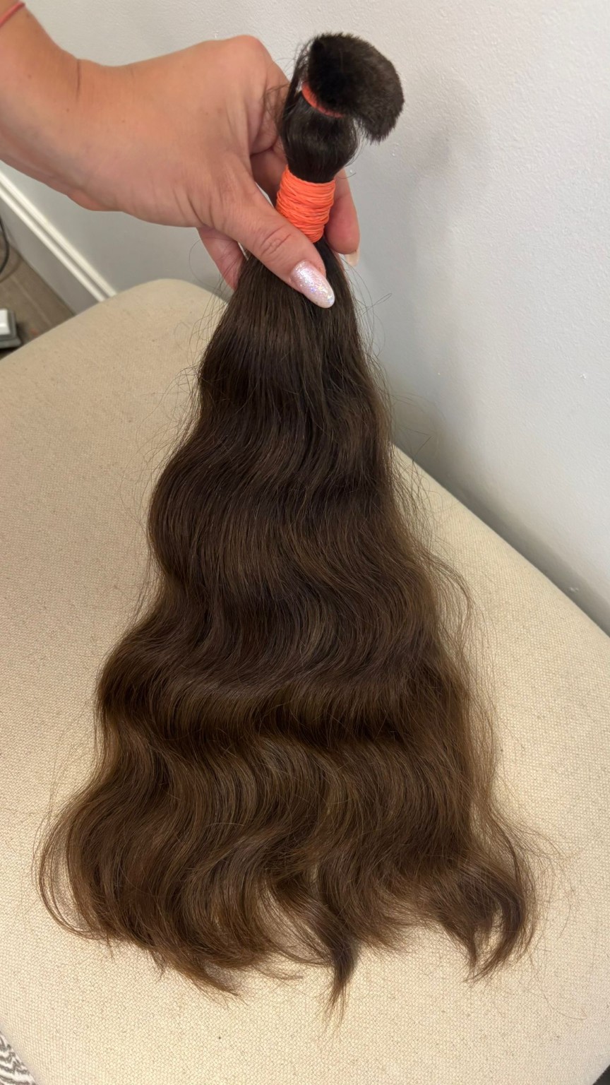 Long dimensional brunette wavy extension hair selected for custom preparation